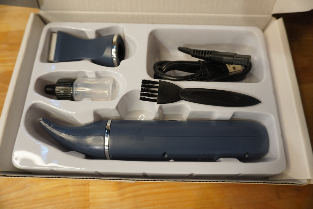 The oneisall paw pad clippers, an extra head, a cable, brush and oil laid out in a box.